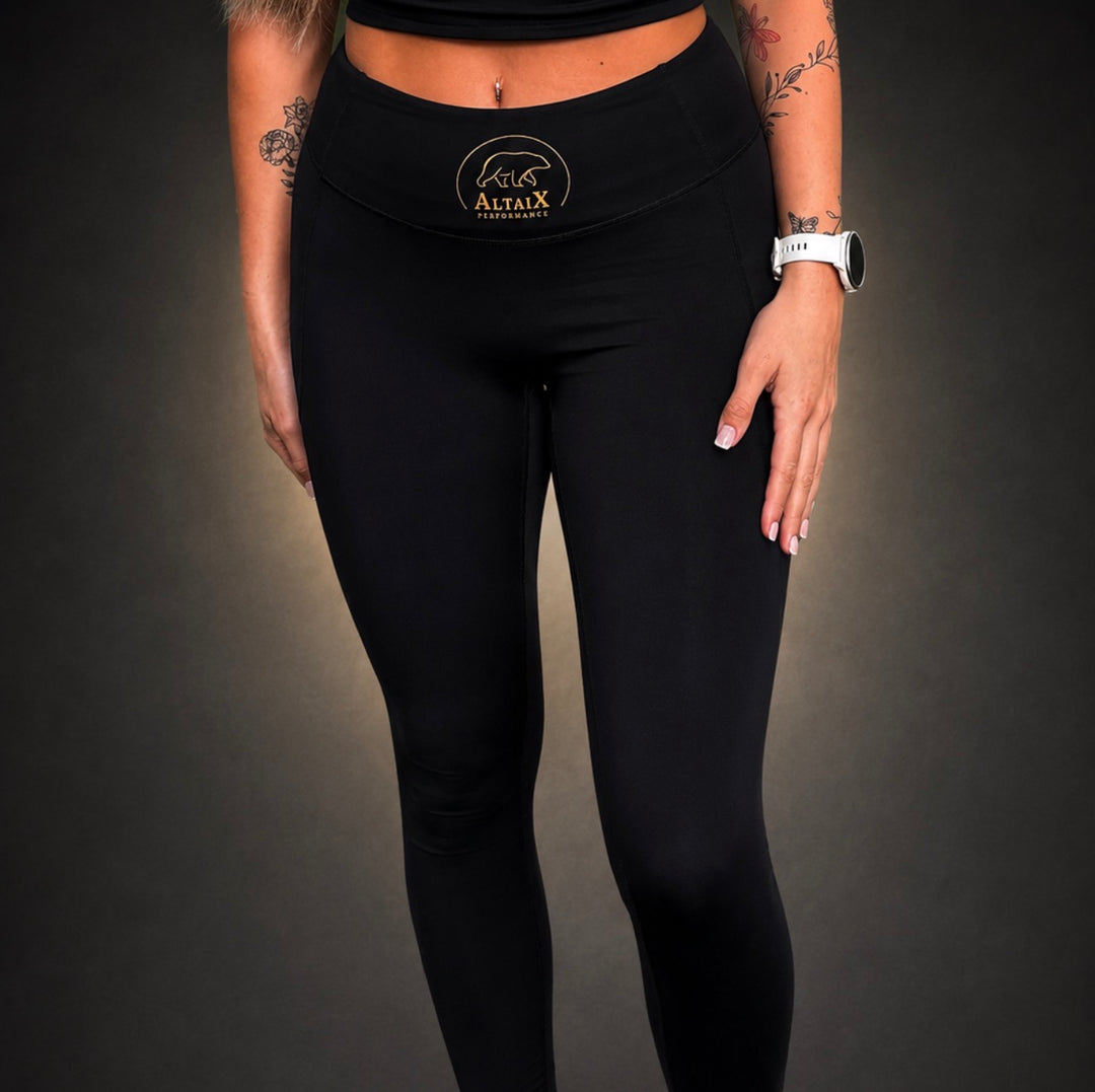 AltaiX First Edition Women's High-Waisted Black Leggings with supportive compression, four-way stretch, signature gold branding and a sculpting fit for gym training, HYROX, running and everyday wear.