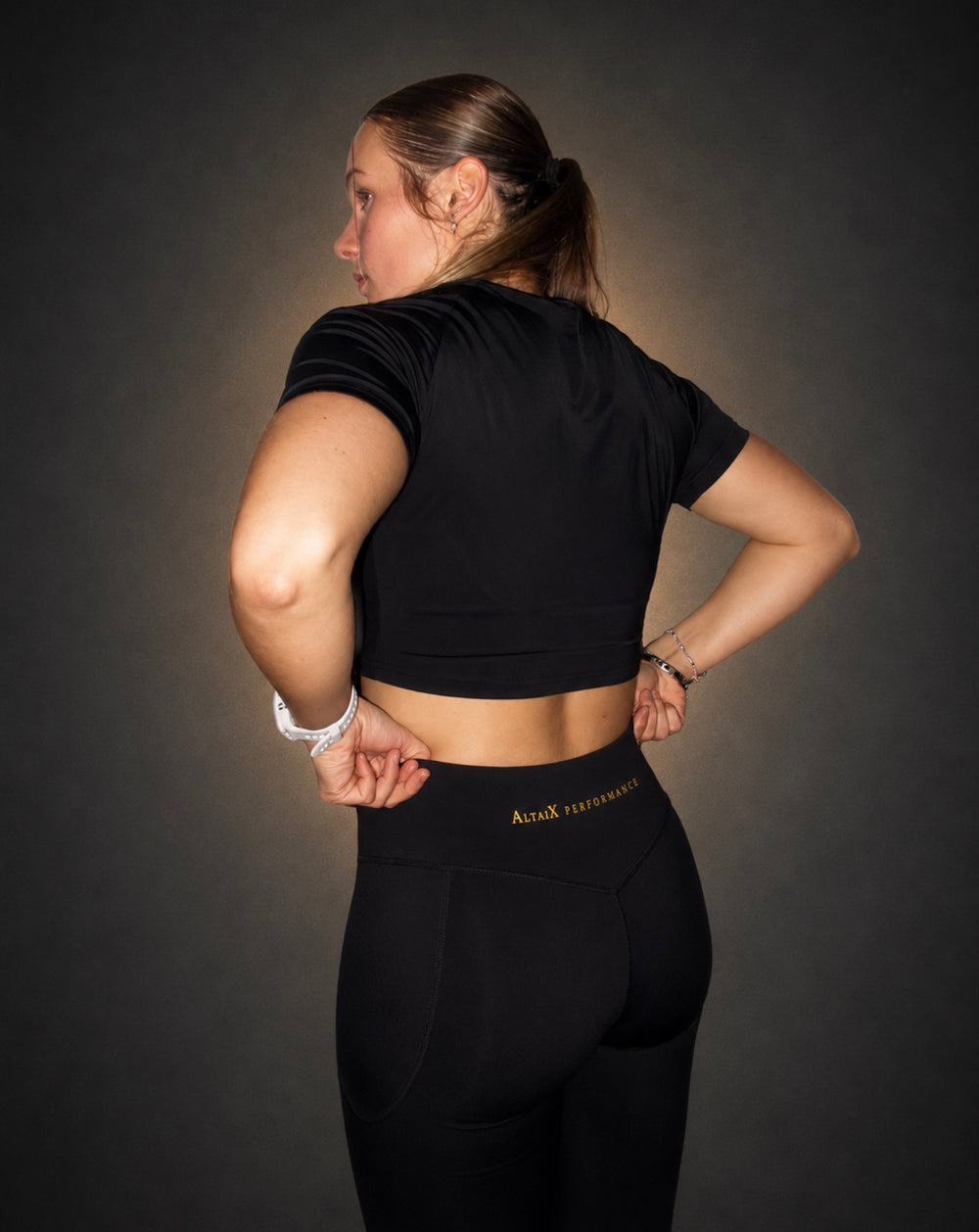 AltaiX First Edition Women's Performance Crop Top in Black with a supportive fitted design, four-way stretch fabric and signature gold branding for gym training, HYROX, strength training and everyday wear.