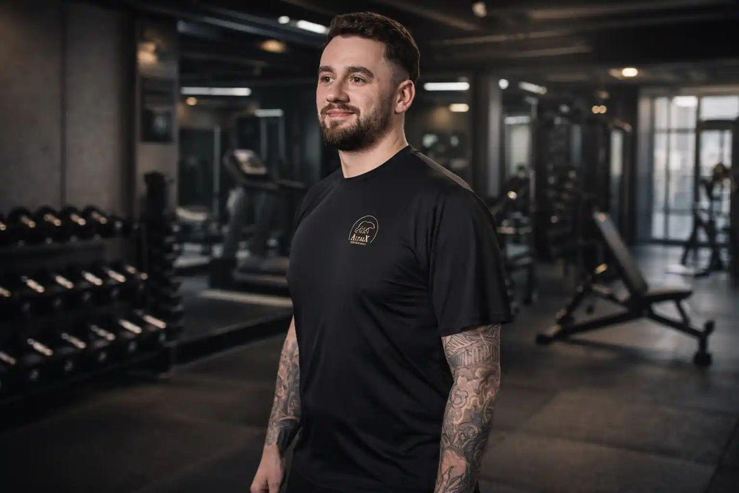 Male model wearing the First Edition Men's Performance T-Shirt in a gym